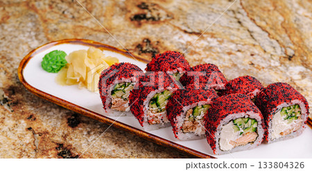 Colorful sushi rolls served on a decorative plate with garnishes 133804326