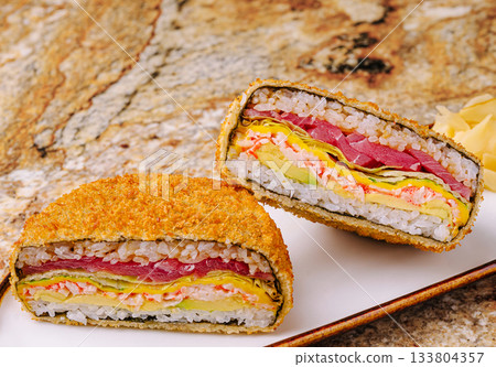 A unique sushi sandwich is displayed on a white plate A unique sushi sandwich is displayed on a white plate 133804357