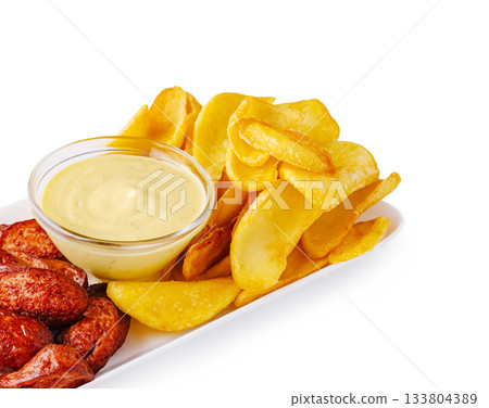 Delicious meal featuring crispy potato chips and savory dip served fresh 133804389