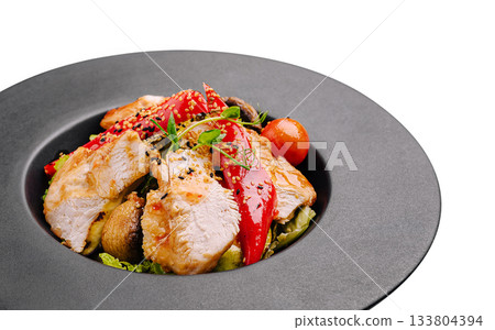 Tasty chicken salad with veggies and sesame seeds in a black bowl Tasty chicken salad with veggies and sesame seeds in a black bowl 133804394