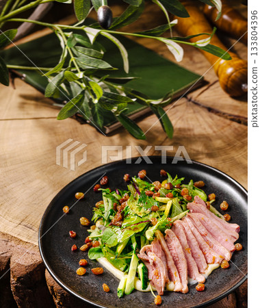 Fresh salad with sliced meat on a rustic wooden table in a cozy setting Fresh salad with sliced meat on a rustic wooden table in a cozy setting 133804396