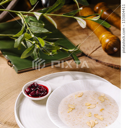 Warm breakfast bowl with almonds and berry sauce on rustic table Warm breakfast bowl with almonds and berry sauce on rustic table 133804411
