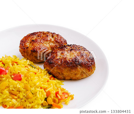 Savory meat patties served with colorful rice dish at a dining table Savory meat patties served with colorful rice dish at a dining table 133804431
