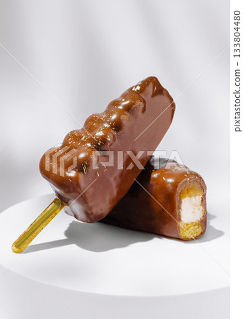 Delicious chocolate-covered popsicles stacked on a white plate Delicious chocolate-covered popsicles stacked on a white plate 133804480