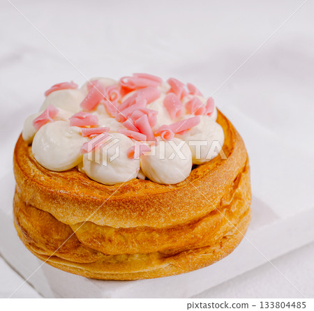 Delicious dessert with cream and pink toppings placed on a white surface Delicious dessert with cream and pink toppings placed on a white surface 133804485