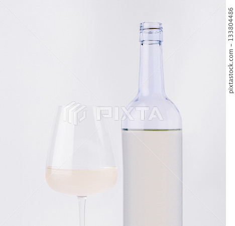 Elegant white wine setup with glass and bottle on a neutral background 133804486