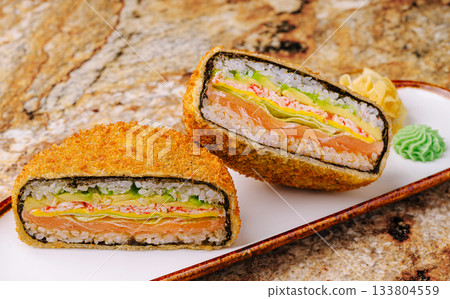 Delicious fried sandwich sushi roll filled with fresh ingredients on a plate 133804559
