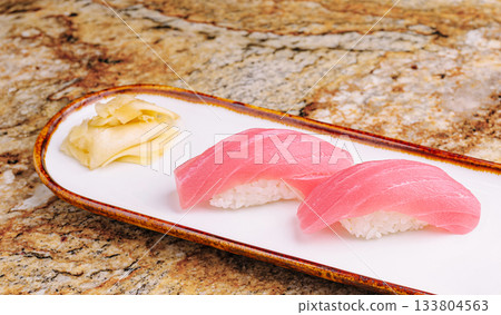 Fresh tuna sushi on a decorative plate with ginger garnish 133804563