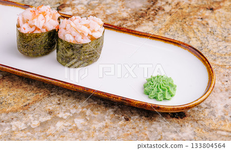 Delicious sushi served on a plate with wasabi on a stone countertop 133804564