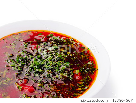 Delicious borscht red soup with fresh herbs and vegetables in a white bowl 133804567