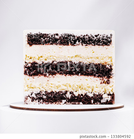 Delicious layered cake with chocolate and vanilla flavors displayed on a stand Delicious layered cake with chocolate and vanilla flavors displayed on a stand 133804592