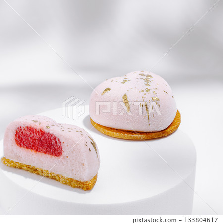 Delicate heart-shaped desserts displayed on a white stand in soft lighting Delicate heart-shaped desserts displayed on a white stand in soft lighting 133804617