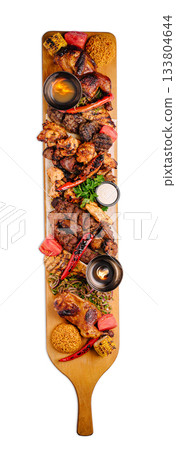 Delicious meat platter served on a wooden board at a festive gathering 133804644