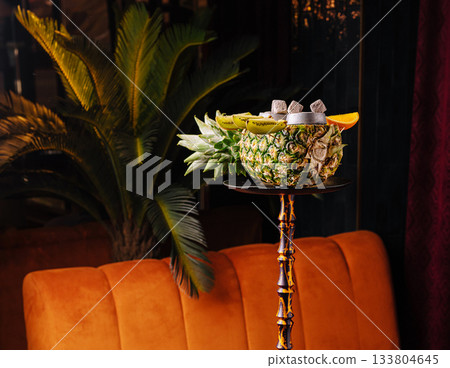 Exotic hookah served in a carved pineapple bowl with kiwi and orange slices 133804645