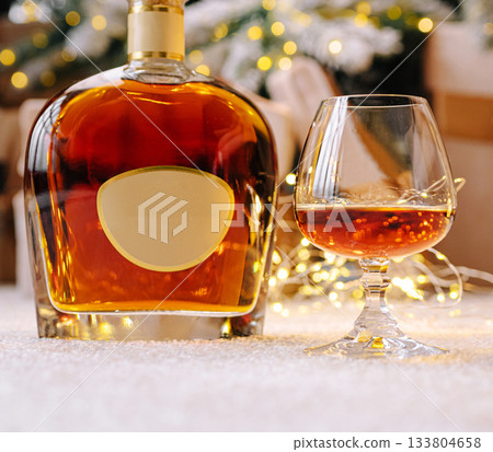 Warm evening with whiskey and festive lights by the cozy fireplace 133804658