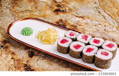 Fresh sushi rolls served on a platter with wasabi and ginger Fresh sushi rolls served on a platter with wasabi and ginger 133804663