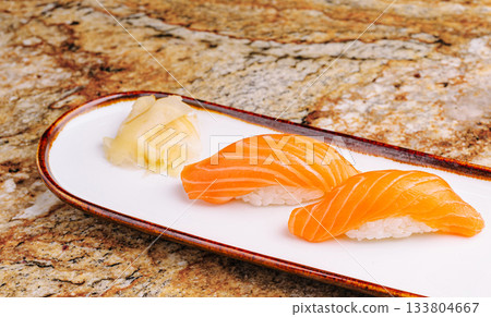 Fresh salmon sushi served on white plate with ginger 133804667