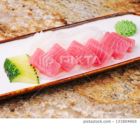 Fresh sashimi arranged on a plate with cucumber and wasabi Fresh sashimi arranged on a plate with cucumber and wasabi 133804668