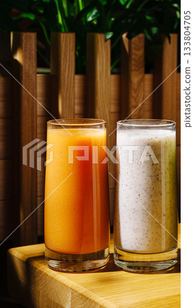 Freshly made fruit and nut drinks on a wooden table in a sunny cafe 133804705