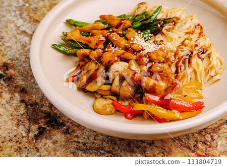 Delicious stir-fry with chicken, vegetables, and noodles served in a bowl 133804719