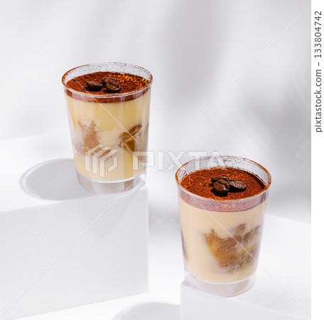 Delicious dessert cups filled with creamy layers and coffee beans on top Delicious dessert cups filled with creamy layers and coffee beans on top 133804742