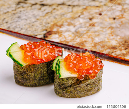 Delicious sushi rolls with salmon roe served on a clean white plate 133804806