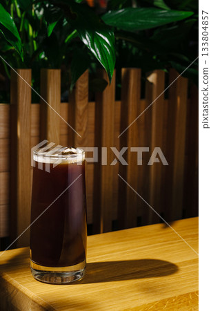 Enjoying a refreshing cold brew coffee in a cozy indoor setting 133804857
