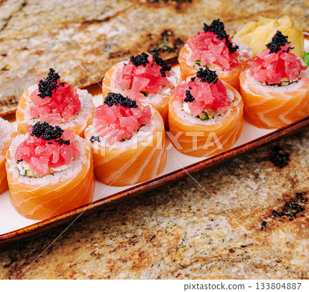 Delicious sushi rolls with fresh toppings served on a platter 133804887