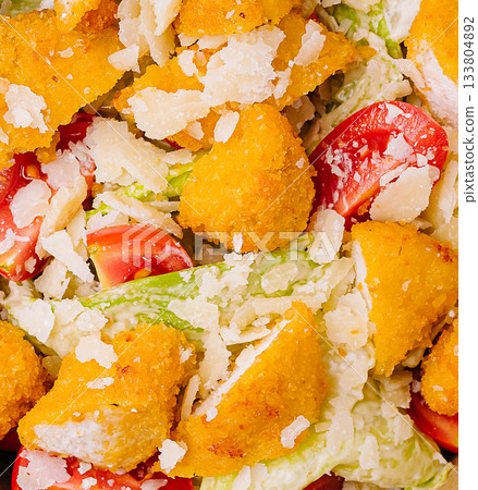 Delicious salad with crispy chicken, fresh vegetables, and cheese topping Delicious salad with crispy chicken, fresh vegetables, and cheese topping 133804892