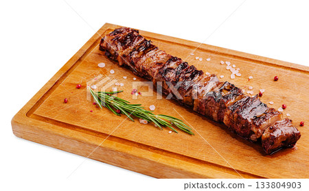 Grilled pork kebab with herbs resting on a wooden cutting board Grilled pork kebab with herbs resting on a wooden cutting board 133804903