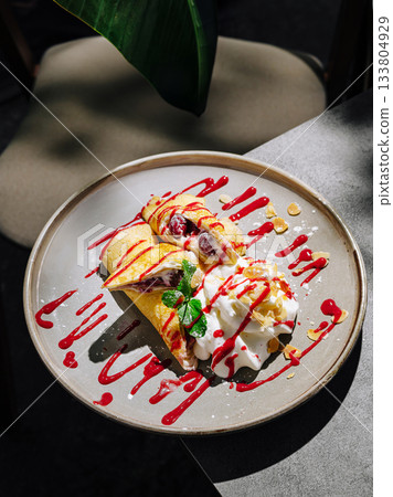 Delicious dessert plate with sweet crepes and cream served in bright light Delicious dessert plate with sweet crepes and cream served in bright light 133804929
