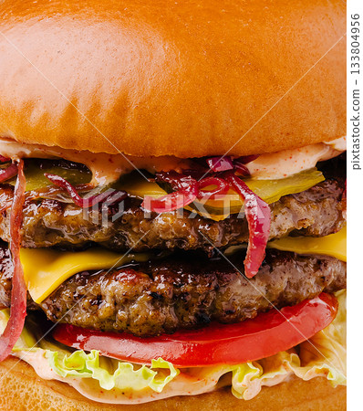 Juicy double cheeseburger with fresh toppings served in a restaurant Juicy double cheeseburger with fresh toppings served in a restaurant 133804956