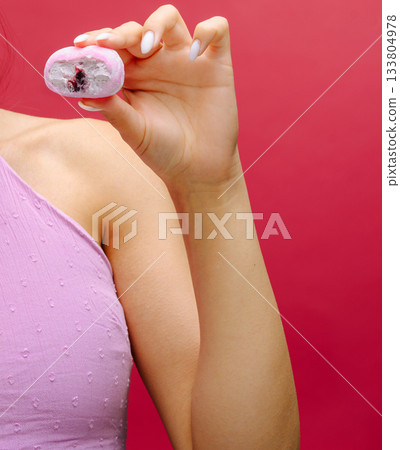 Model showcases colorful dessert against vibrant background in modern setting Model showcases colorful dessert against vibrant background in modern setting 133804978