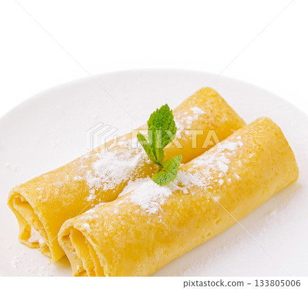 Delicious crepes served on a white plate with a mint garnish 133805006
