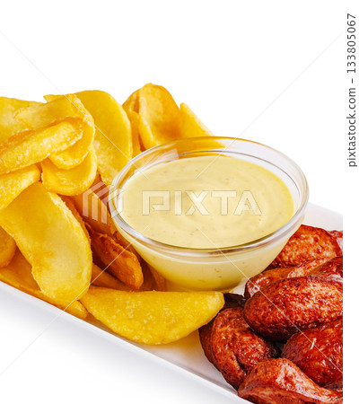Delicious platter of crispy potatoes and savory sausage with dip 133805067