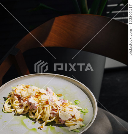 Pasta dish served on a plate in a modern setting during daylight 133805117