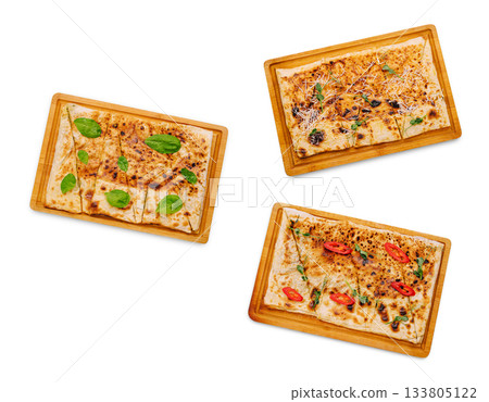 Delicious flatbreads with various toppings served on wooden trays Delicious flatbreads with various toppings served on wooden trays 133805122