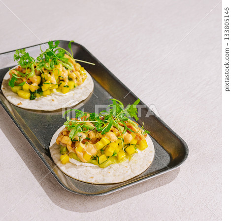 Delicious tacos filled with fresh mango and chicken served on a tray Delicious tacos filled with fresh mango and chicken served on a tray 133805146