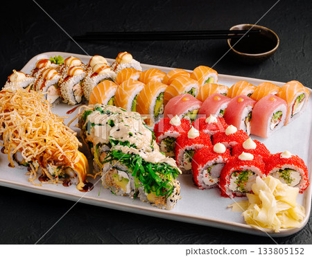 Sushi platter featuring various types of sushi served on a white plate Sushi platter featuring various types of sushi served on a white plate 133805152
