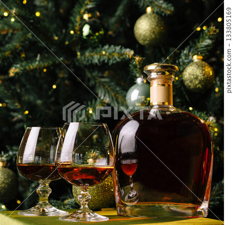 Holiday celebration with whiskey and glasses by Christmas tree Holiday celebration with whiskey and glasses by Christmas tree 133805169