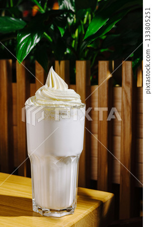 Delicious milkshake topped with whipped cream at a cozy cafe 133805251