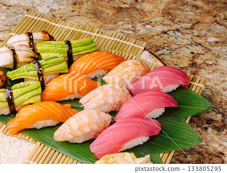 Traditional sushi platter displayed on bamboo mat with fresh ingredients Traditional sushi platter displayed on bamboo mat with fresh ingredients 133805295