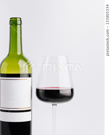 Red wine bottle and glass on a simple background for tasting experience 133805334