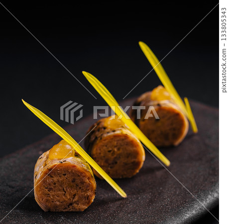 Delicious gourmet dish served on a dark plate with vibrant garnishes Delicious gourmet dish served on a dark plate with vibrant garnishes 133805343