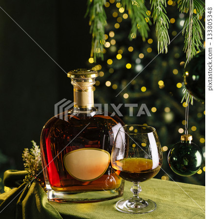 Enjoying rich whiskey beside a festive Christmas tree at a holiday gathering Enjoying rich whiskey beside a festive Christmas tree at a holiday gathering 133805348