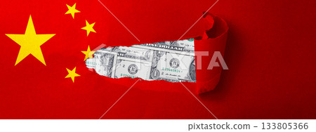 World map with the country of China. Ripped paper reveals an American dollar bill. Economic relationship and interdependence between China and the United States 133805366