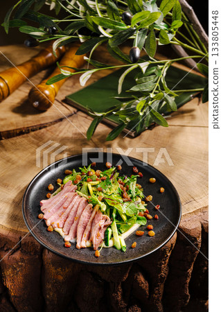Delicious duck breast served with fresh greens on a rustic wooden table 133805448