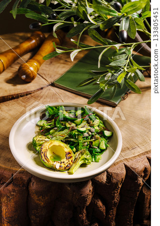 Grilled vegetables and avocado served on wooden table with olive branches Grilled vegetables and avocado served on wooden table with olive branches 133805451