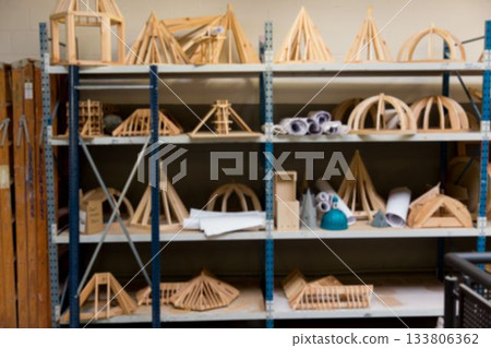 Flat design metal shelving unit is showing wooden architecture models in studio featuring teal hat Flat design metal shelving unit is showing wooden architecture models in studio featuring teal hat 133806362