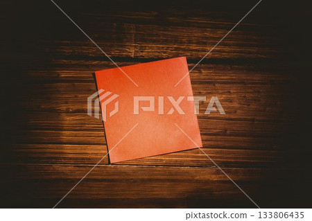 Square shaped orange paper on wooden floor Square shaped orange paper on wooden floor 133806435
